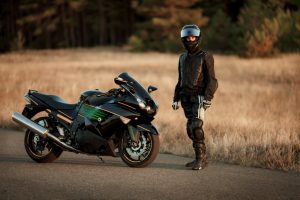 Motorcycle,Driver,In,A,Helmet,And,Leather,Jacket,Stands,On